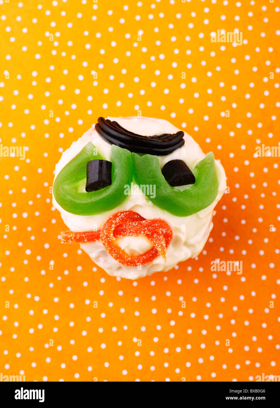 La torta con la faccina sorridente su sfondo maculato Foto Stock