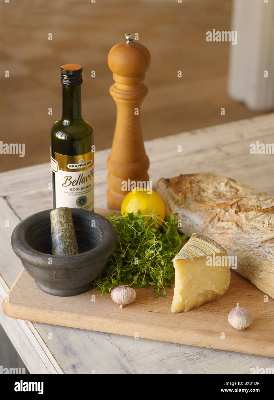 Pane, formaggio, olio e erbe sul tagliere Foto Stock