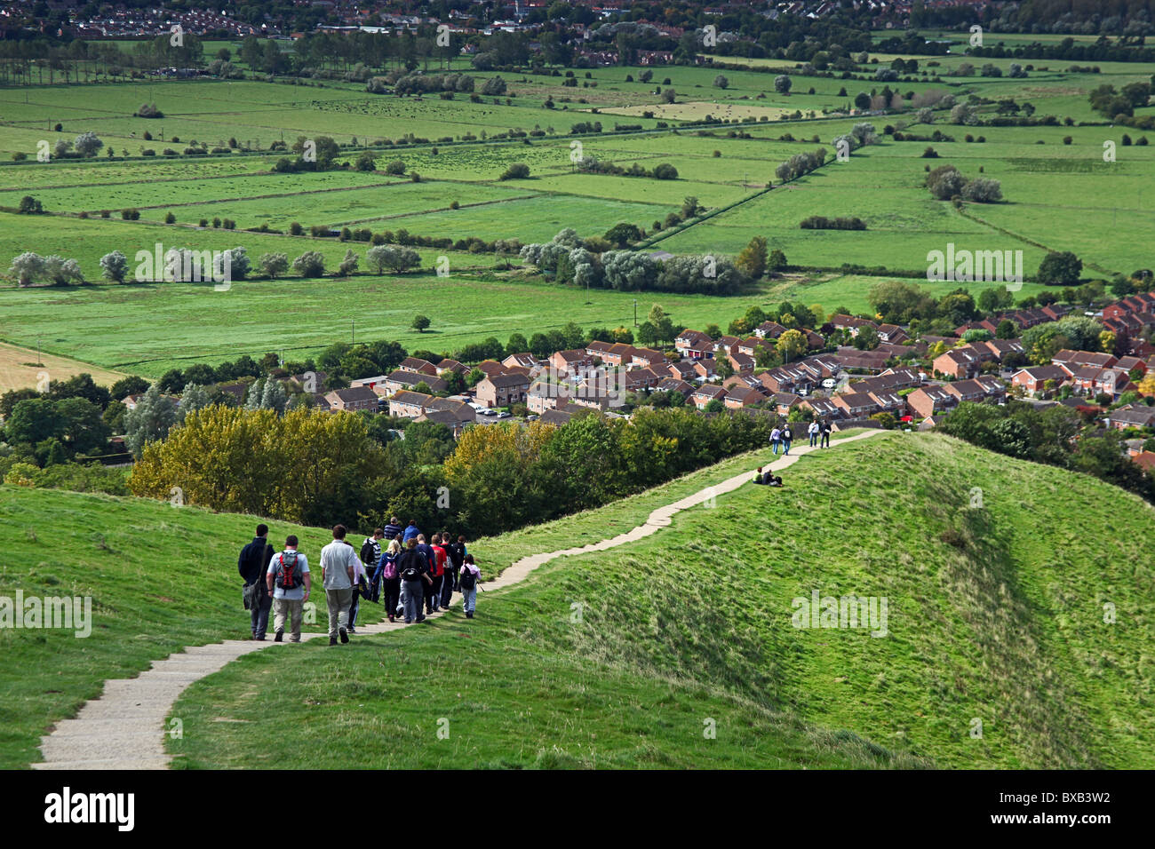 Un gruppo di escursionisti sul sentiero che conduce dal vertice di Glastonbury Tor su cui si affaccia il livelli di Somerset, Inghilterra, Regno Unito Foto Stock