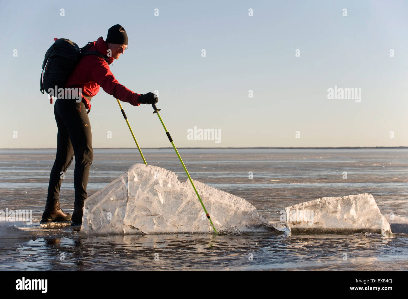 L'uomo pattinaggio sul lago ghiacciato e guardando glaçon Foto Stock