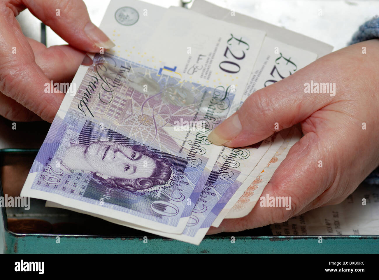 Titolare di pensione o di rendita tenendo 20 pound note valuta inglese UK Foto Stock