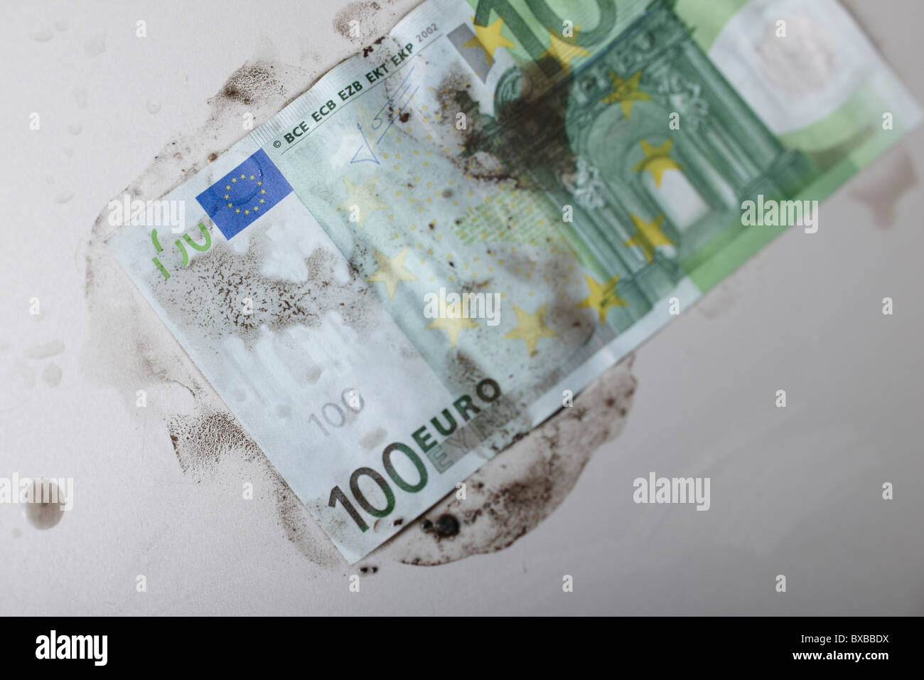 La banconota ricoperta di sporcizia, immagine simbolica di riciclaggio del denaro sporco Foto Stock
