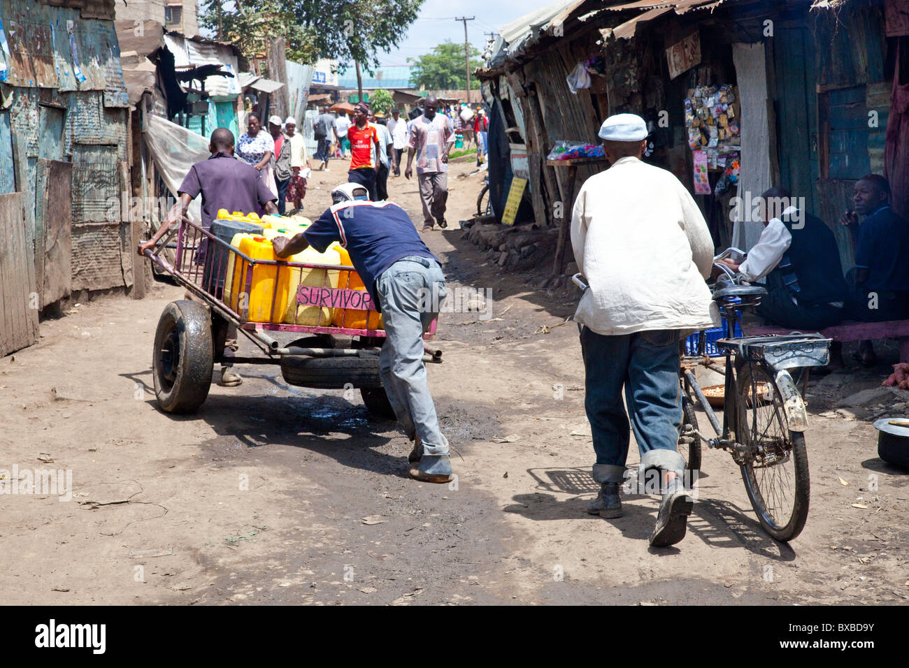 Gli uomini di spingere i contenitori di acqua fresca attraverso il Mathare slum di Nairobi, in Kenya Foto Stock