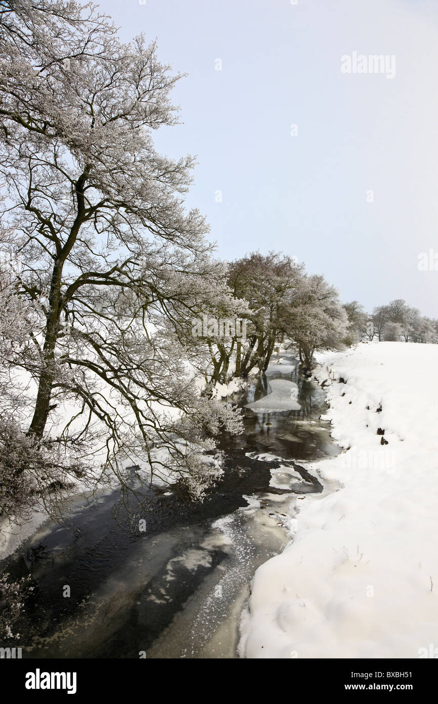 Paese scena di neve e di collettore di fiume nel Parco Nazionale di Peak District in inverno. Longnor, Staffordshire, Regno Unito, Gran Bretagna Foto Stock