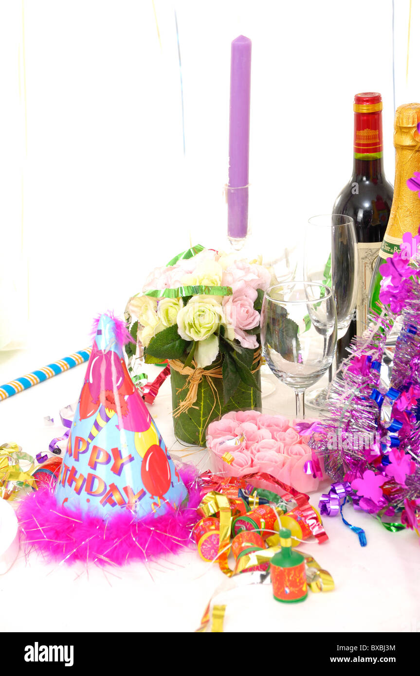 Party hat e le bottiglie di vino in una festa di compleanno Foto Stock