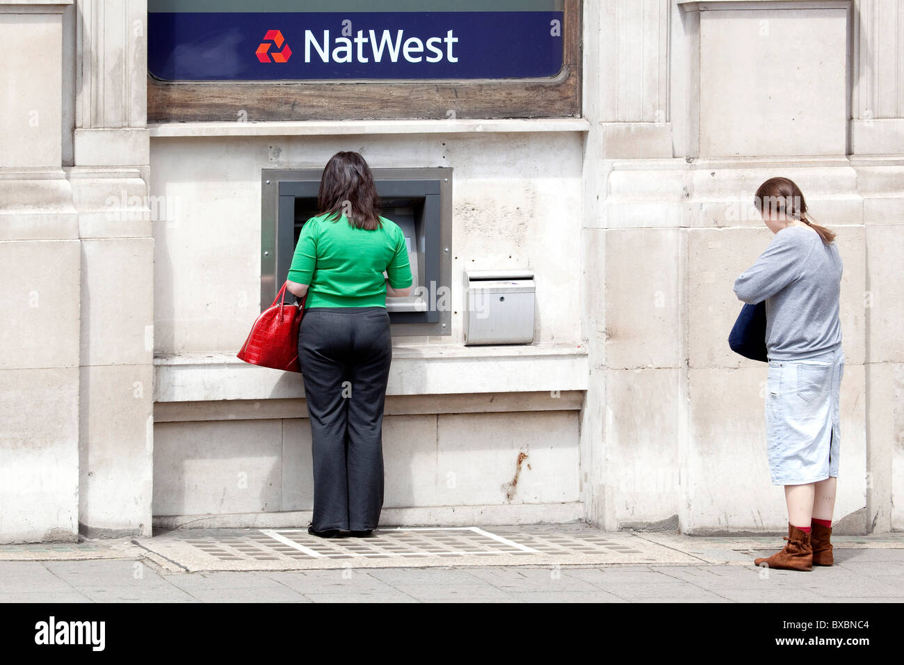 Donna al bancomat della NatWest Bank in London, England, Regno Unito, Europa Foto Stock