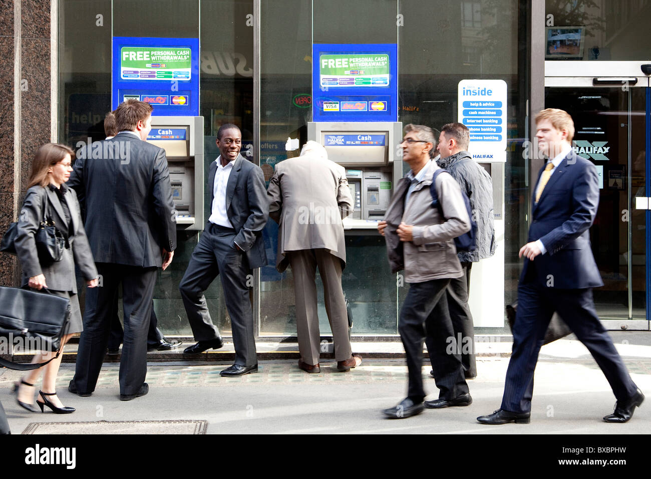 I passanti presso bancomat di Halifax Bank in London, England, Regno Unito, Europa Foto Stock