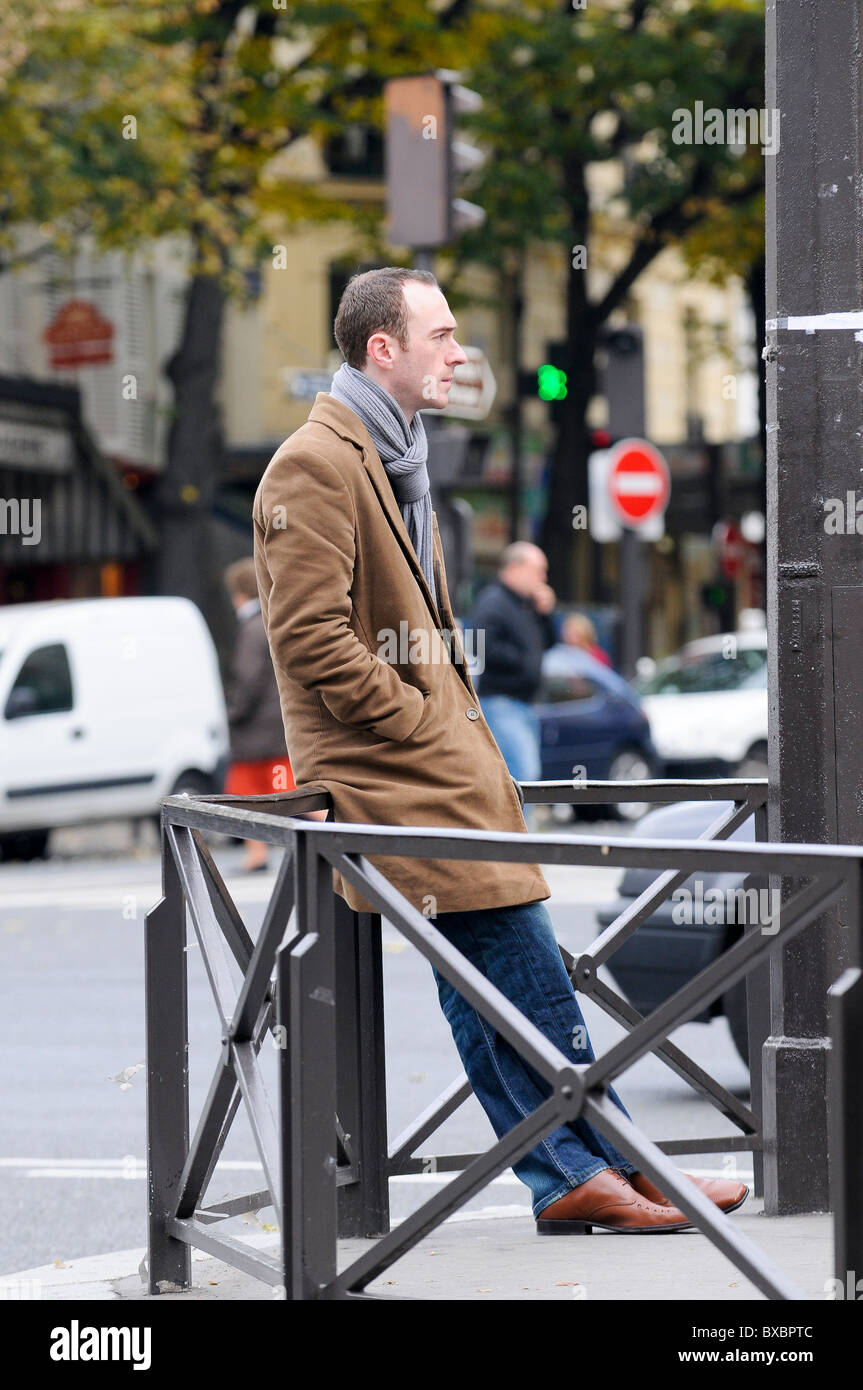 Il francese in un cappotto appoggiato sulle ringhiere Foto Stock
