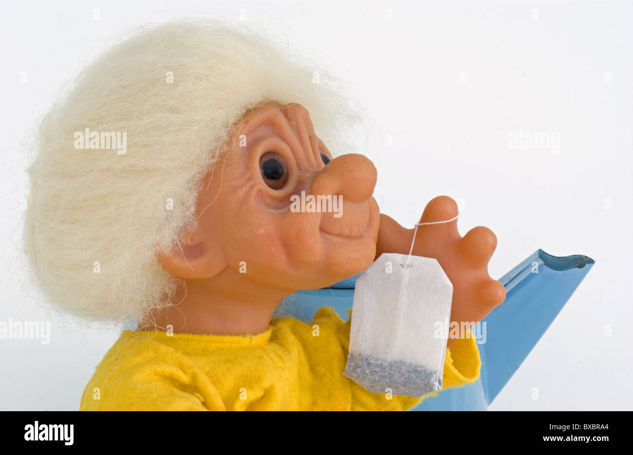 Il troll della nonna con teabag fresco e teakettle in background sta diventando pronto per preparare un po' di tè caldo. Foto Stock