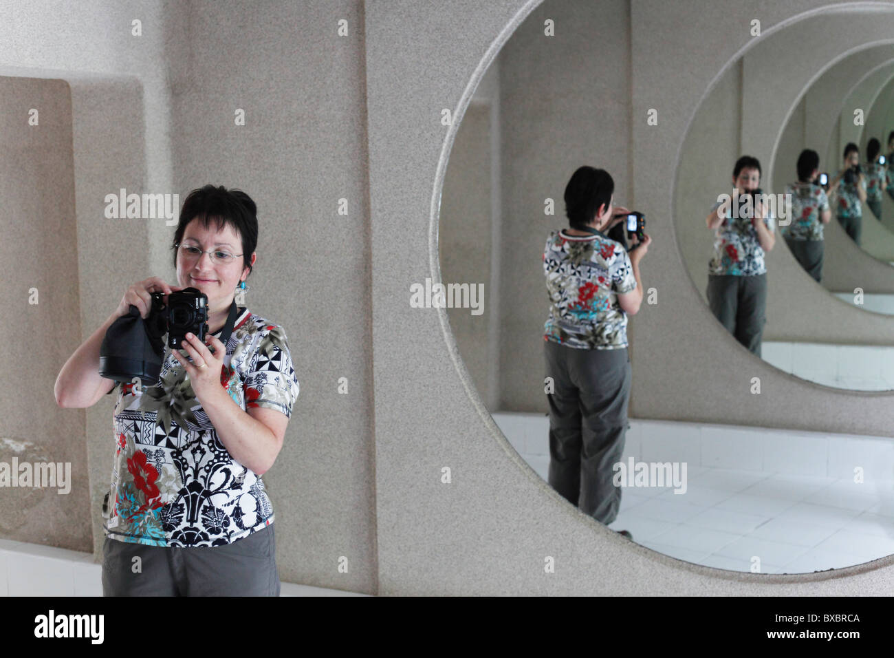 Donna con una telecamera in una sala degli specchi, Jameos del Agua, progettato da César Manrique, Lanzarote, Isole Canarie, Spagna, Europa Foto Stock