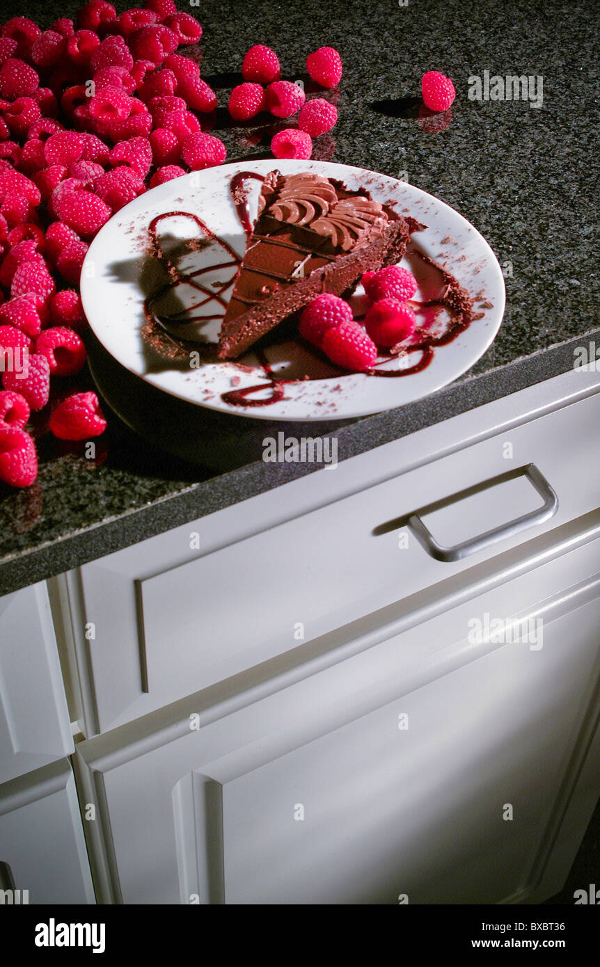 Banco di cucina top con piatto da dessert al cioccolato torta al lampone Foto Stock