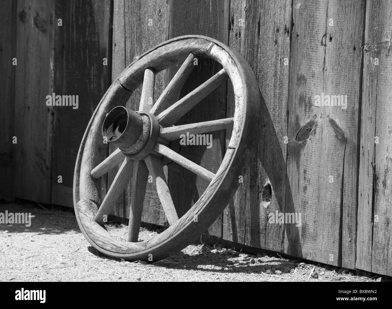 Vecchia ruota di carro appoggiata contro il granaio in legno, Sonoma County, California, Stati Uniti d'America, in bianco e nero Foto Stock