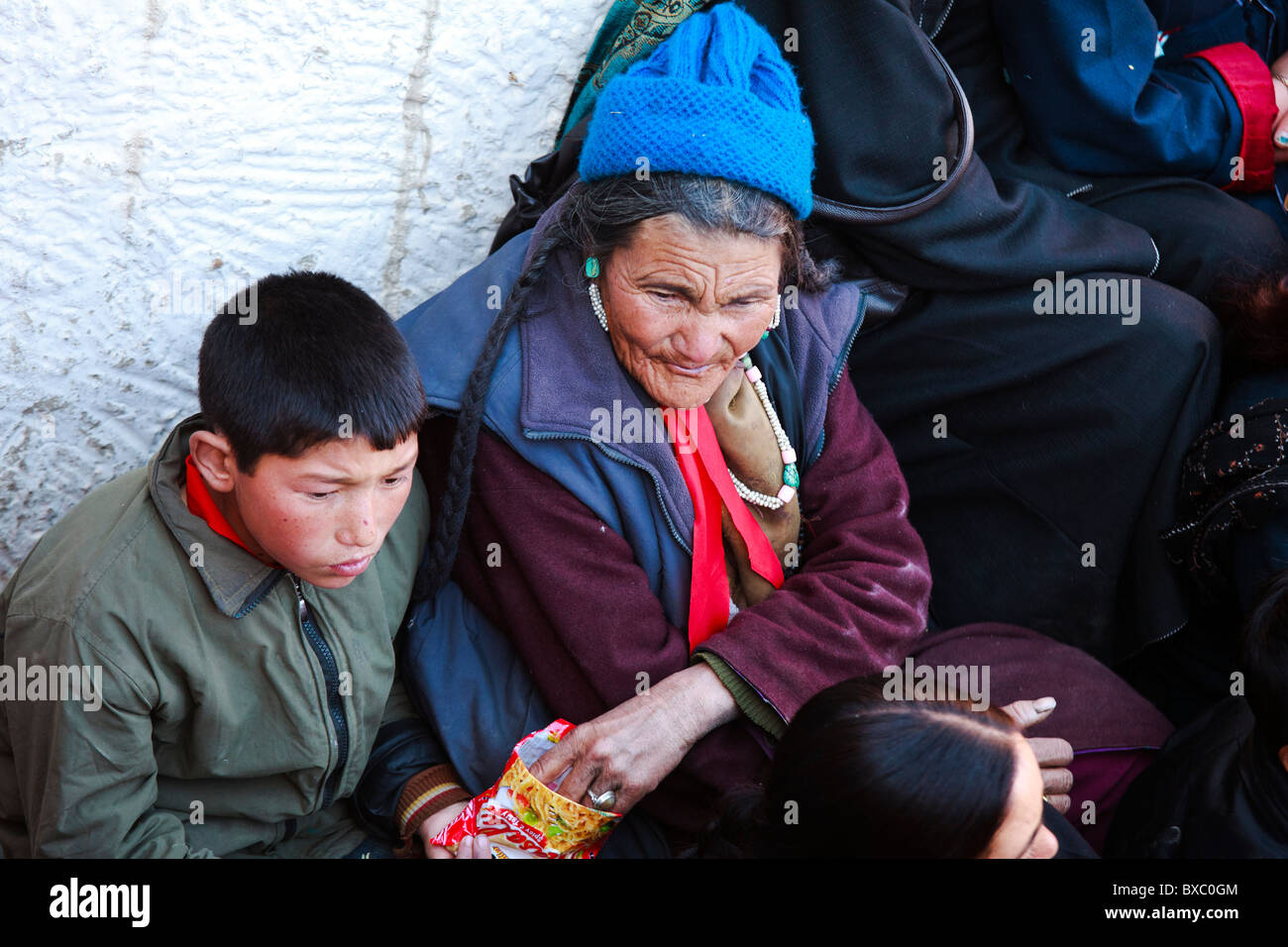 Una donna ladakhi spuntini di condivisione con un ragazzo giovane Foto Stock