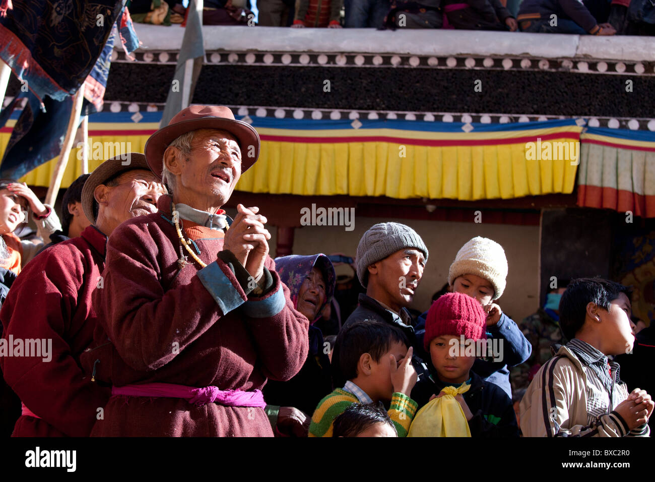 Gli abitanti di un villaggio Ladakhi pregando con loro le mani incrociate Foto Stock