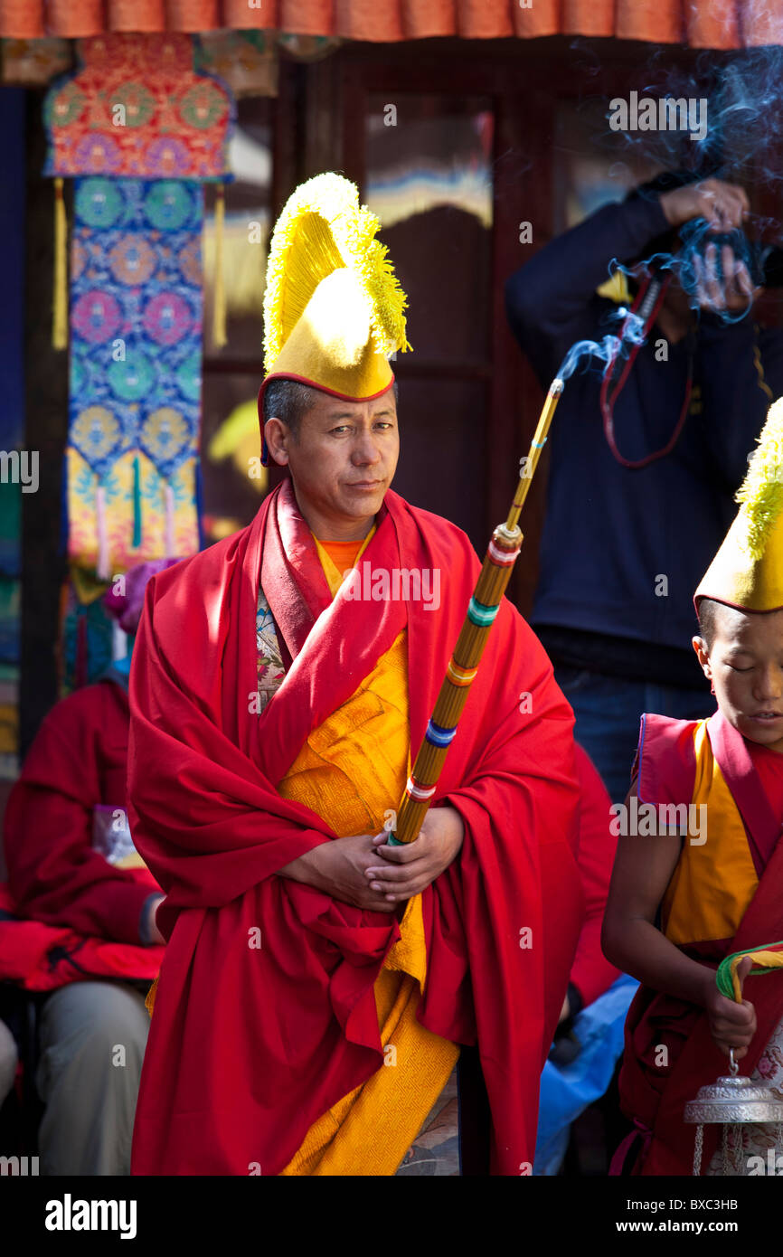 Un ladakhi monaco buddista (lama) in Bright costume rosso tenendo un  cerimoniale di incenso stick Foto stock - Alamy