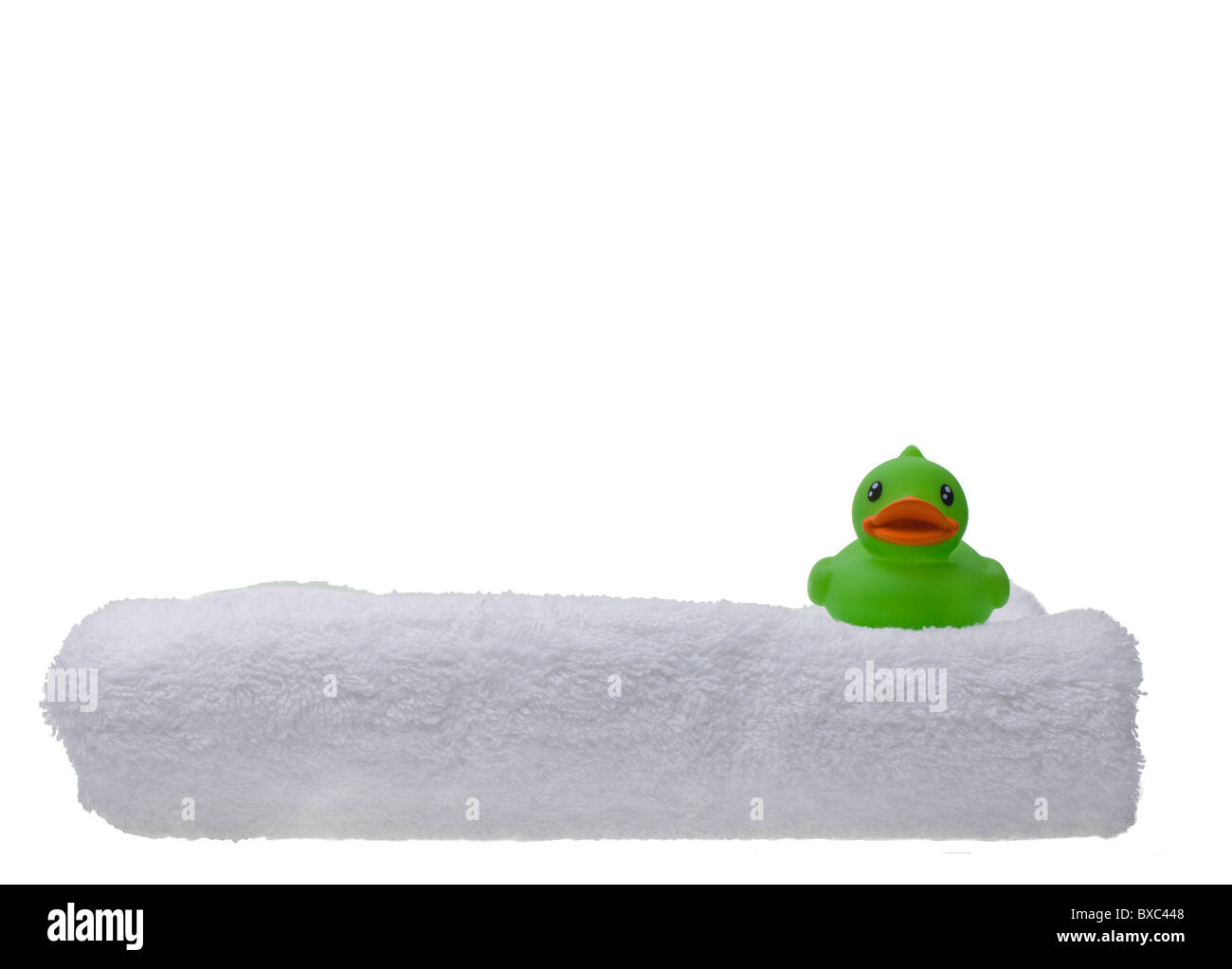 Verde anatra di gomma su un soffice asciugamano bianco isolata contro un bianco di sfondo senza giunture Foto Stock