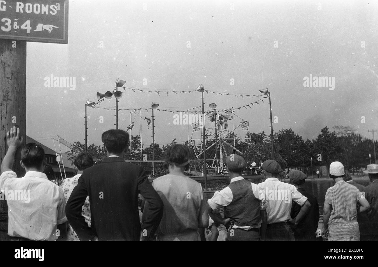 Cinque intrepidi volantini di eseguire durante il Circus carnaval 1920 S 1930 entertainment guardando pubblico viaggia trapezio la moda Foto Stock