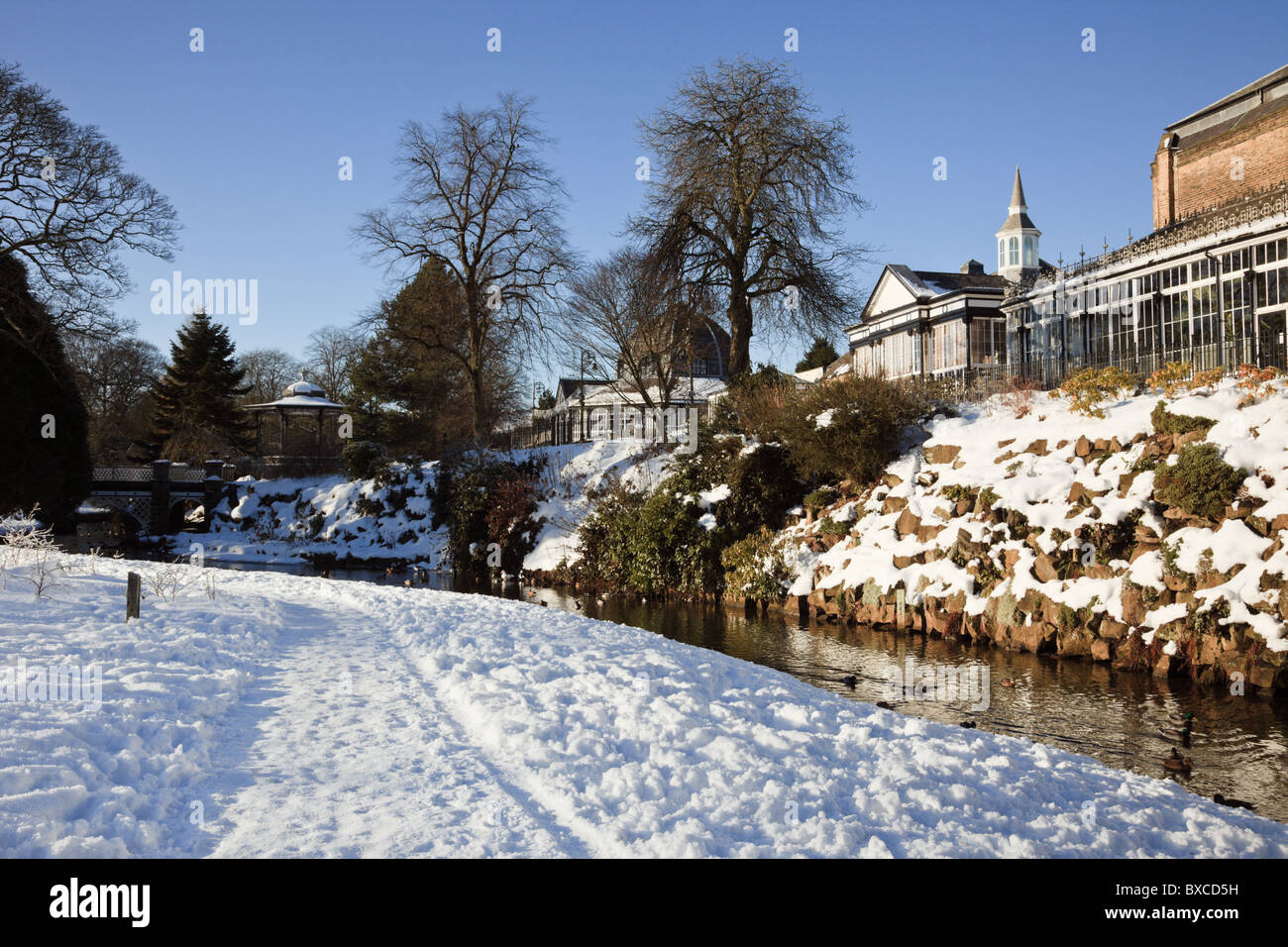 Buxton, Derbyshire, Inghilterra, Regno Unito, Europa. Padiglione e il Pavilion Gardens riverside percorso con la neve in inverno Foto Stock