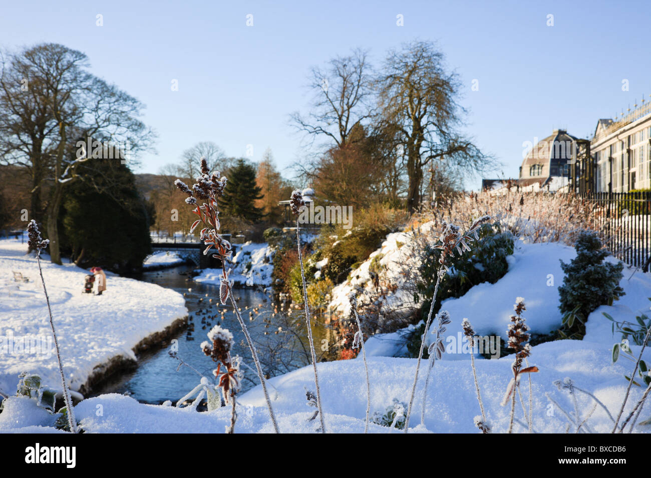 Buxton, Derbyshire, Inghilterra, Regno Unito, Europa. Pavilion Gardens fiume con la neve in inverno Foto Stock