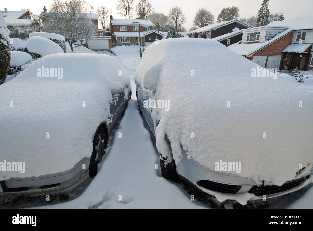 Neve che ricoprono le auto e le case in strada residenziale Warlingham Surrey, Inghilterra Regno Unito Gran Bretagna congelati. North Downs village. L'inverno. Foto Stock