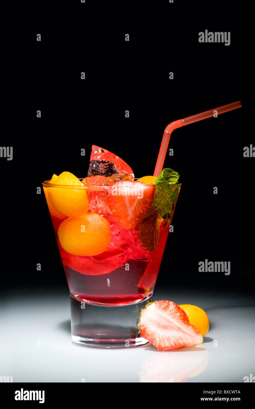 Viola sogni cocktail: misto di bevande alcoliche, piccola arancia, fragola, ghiaccio, leaf Foto Stock