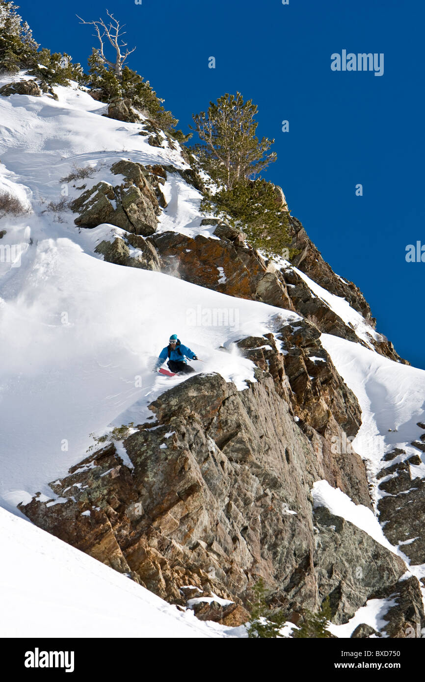 Un uomo fa un giro sopra una grande scogliera in Wasatch backcountry. Foto Stock