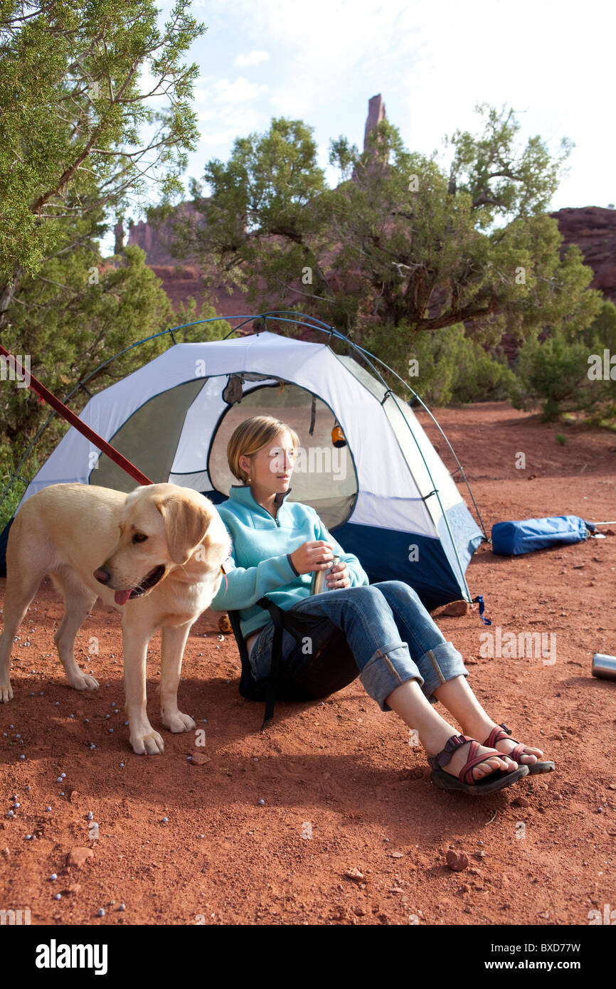 Una donna e il suo cane godere di una mattina di campeggio al di fuori del paese di Moab, Utah. Foto Stock