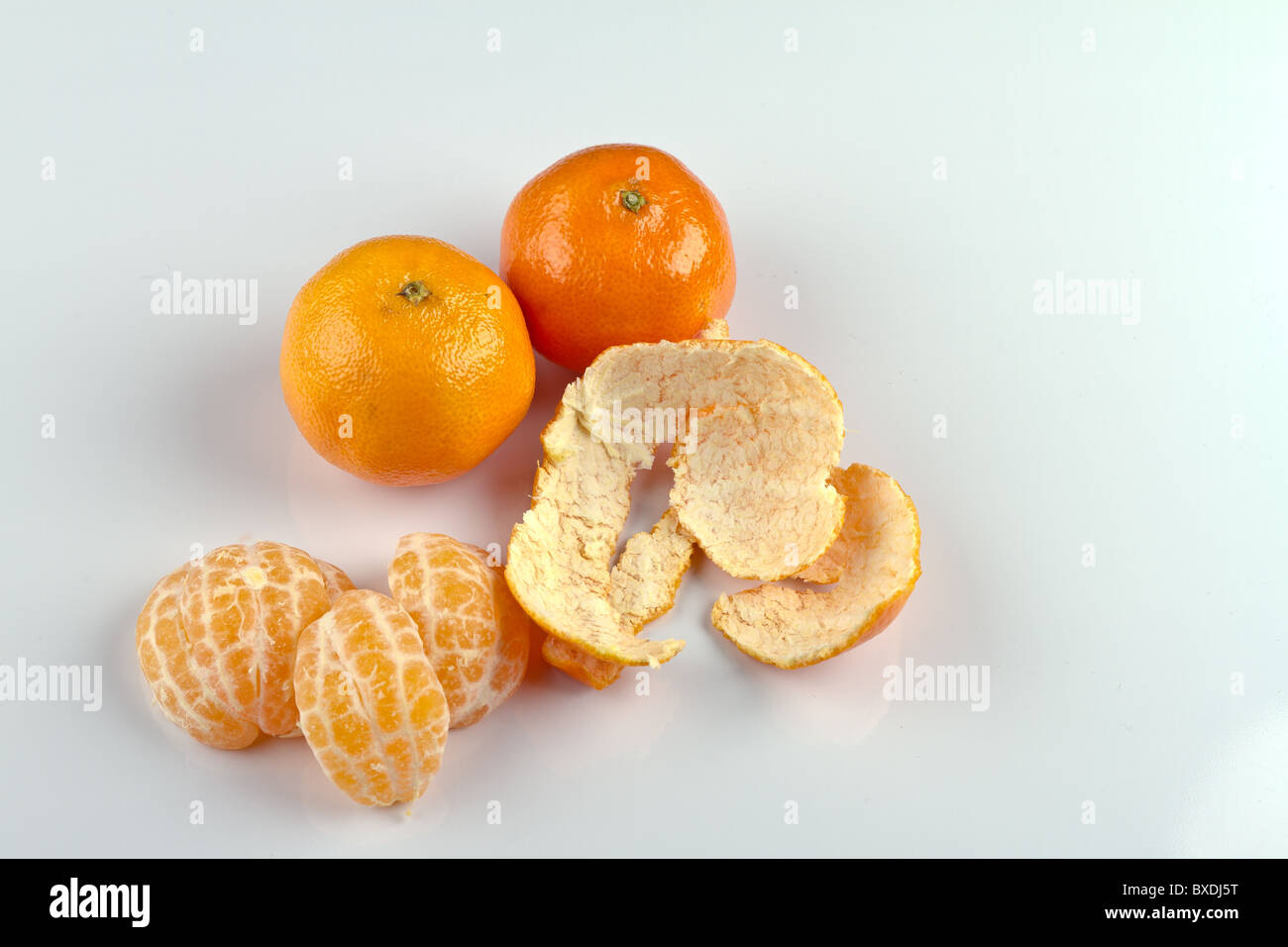 Sbucciate Clementina e il foro clementine sulla superficie bianca Foto Stock