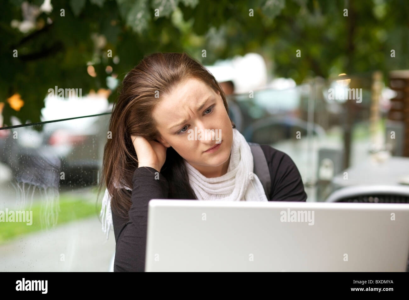 Sottolineato giovane donna con un computer portatile per esterno Foto Stock