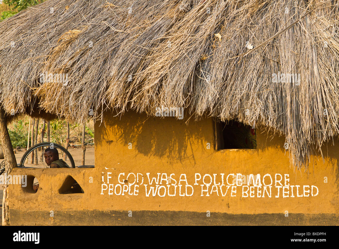 Capanna con commento morale e un uomo che guarda fuori, Kawaza Village, Zambia, Africa. Queste persone sono di Kunda tribù. Foto Stock