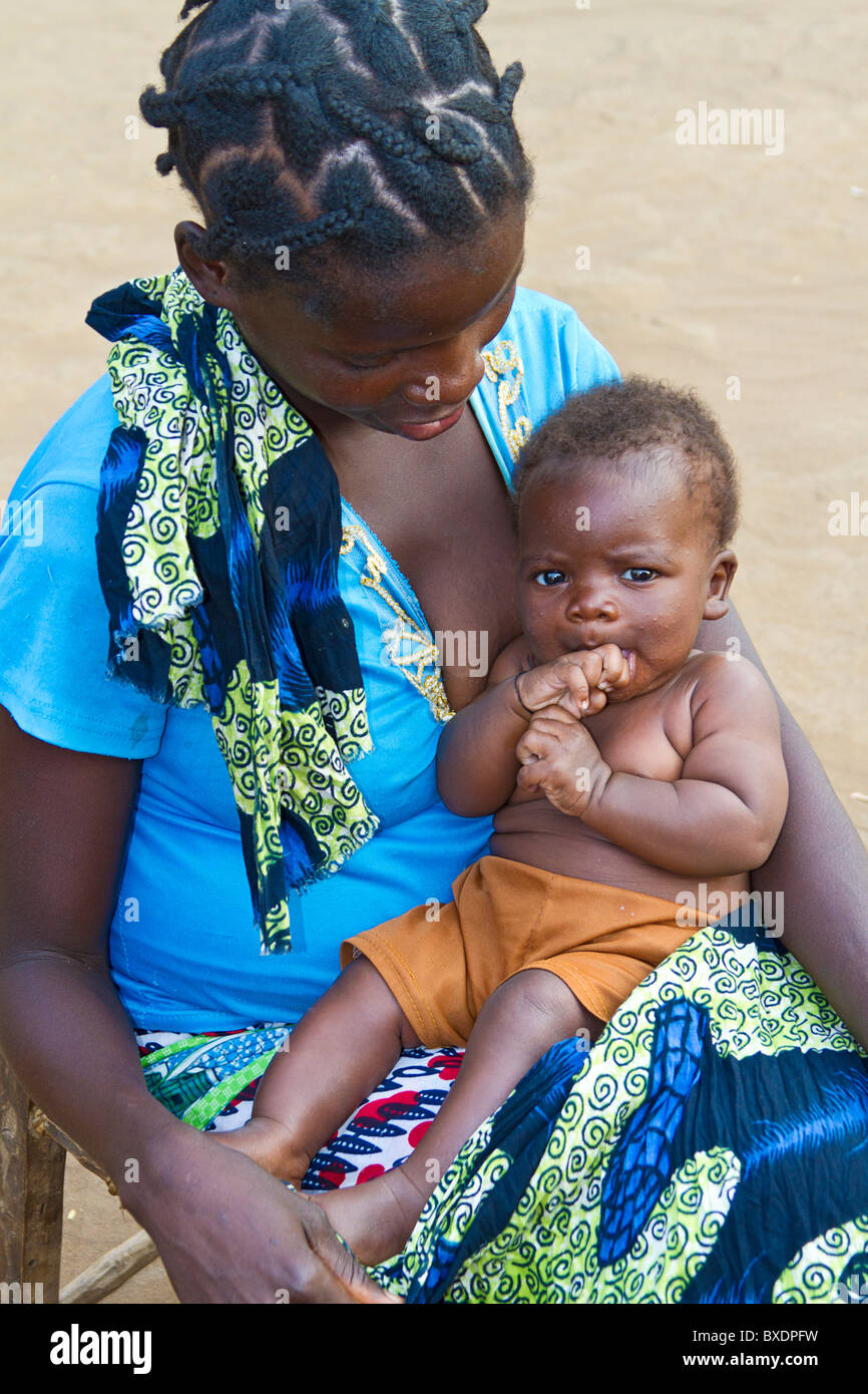 Giovane madre detiene il suo bambino nel suo villaggio, Kawaza, Zambia, Africa. Queste persone sono di Kunda tribù. Foto Stock