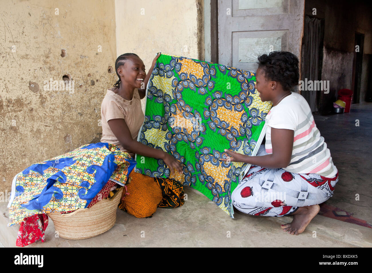 Una giovane donna vende il panno e prodotti tessili da porta a porta in Dodoma, Tanzania Africa Orientale. Foto Stock
