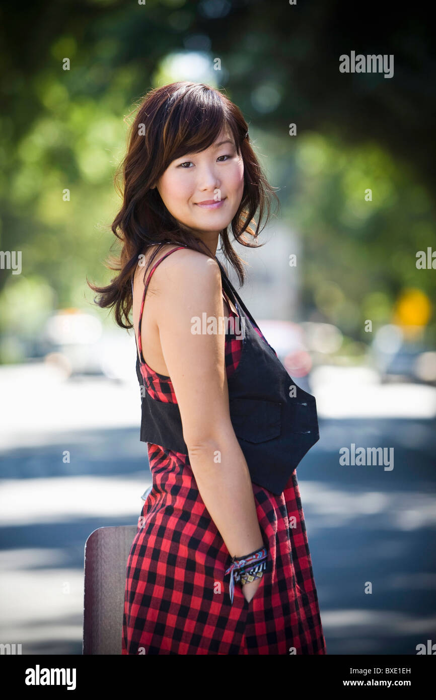 Il coreano sorridente donna in piedi all'aperto Foto Stock
