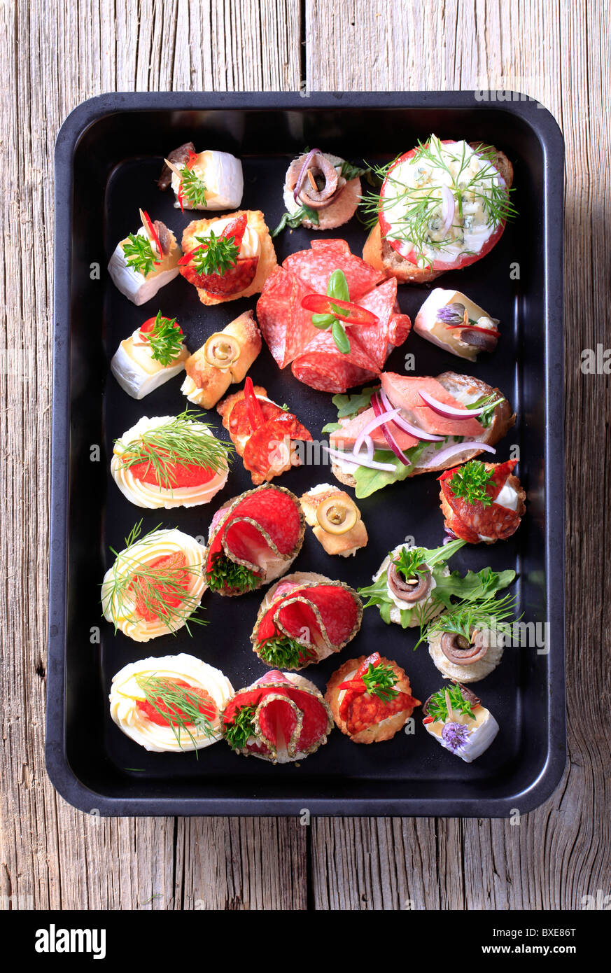 Assortimento di antipasti su un vassoio nero Foto Stock