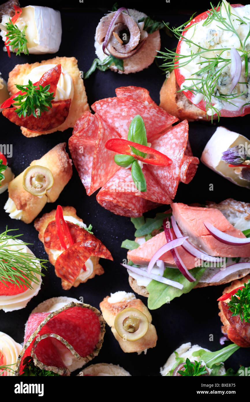 Assortimento di antipasti su un vassoio nero Foto Stock