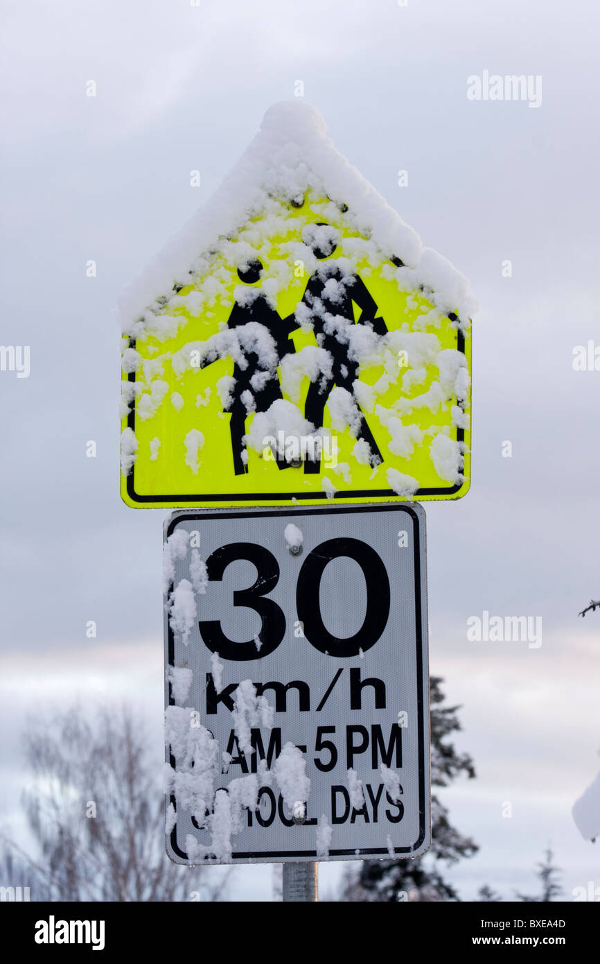 Coperte di neve zona scuola segnale di limite di velocità in inverno-Victoria, British Columbia, Canada. Foto Stock