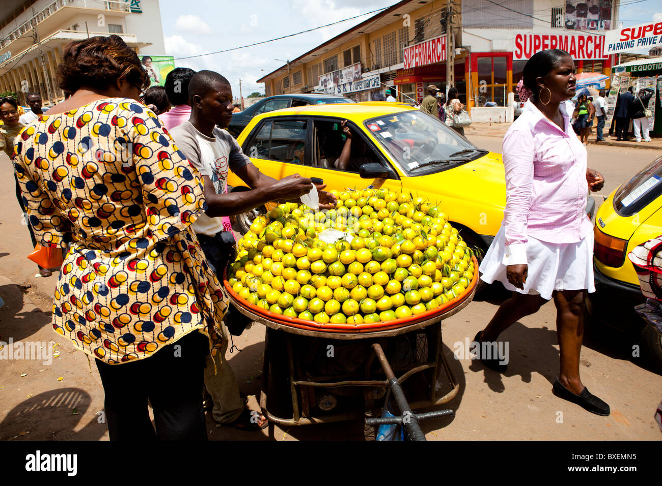 L'uomo per la vendita di frutta strada trafficata Yaoundé Camerun Foto Stock