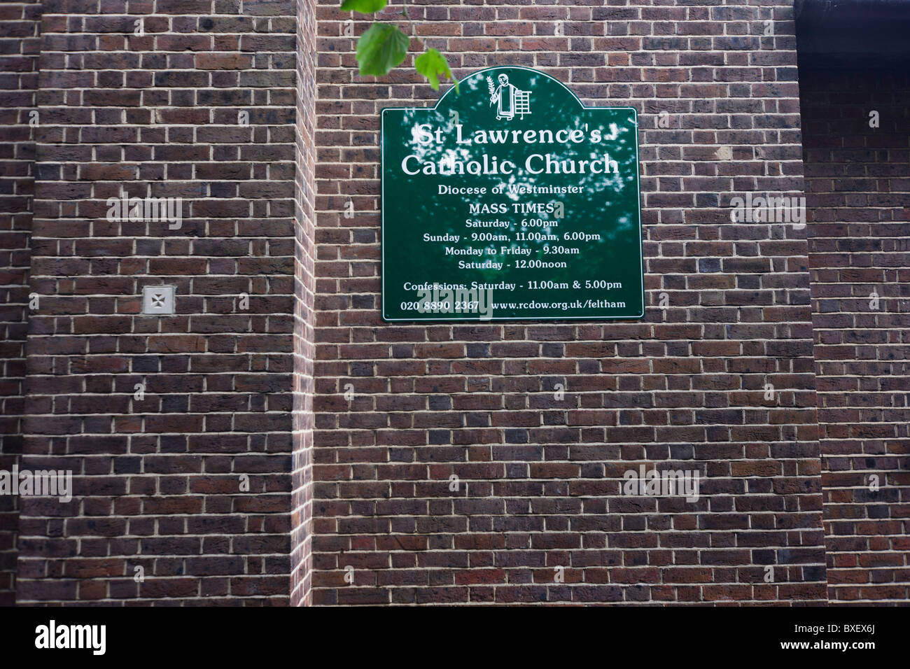 Nome esterno, i tempi per la messa e segno di contatto per San Lorenzo della chiesa cattolica a Feltham, Londra. Foto Stock