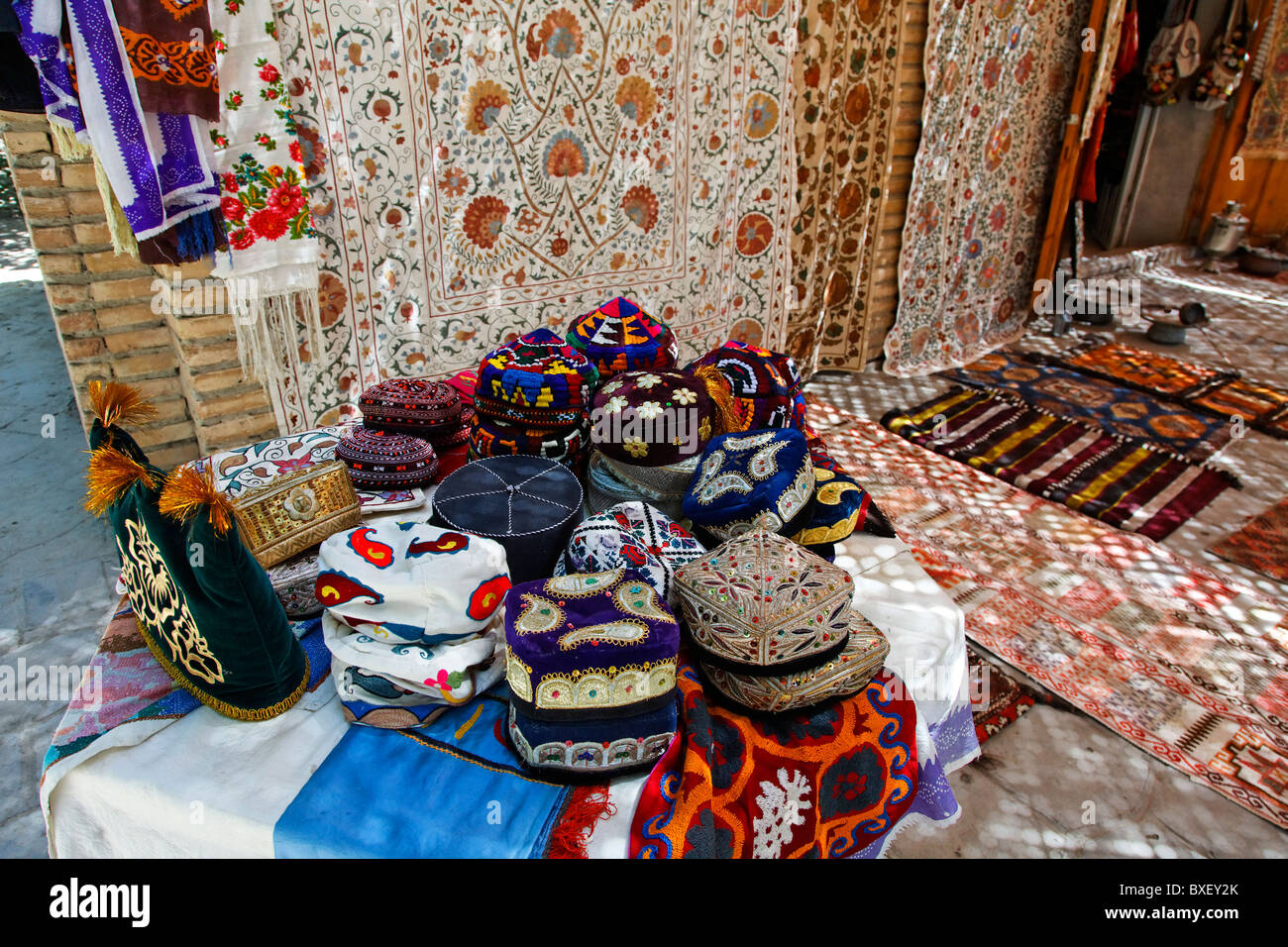 Uzbekistan - Bukhara - display negozio di tappeti di souvenir e cappelli  tradizionali Foto stock - Alamy