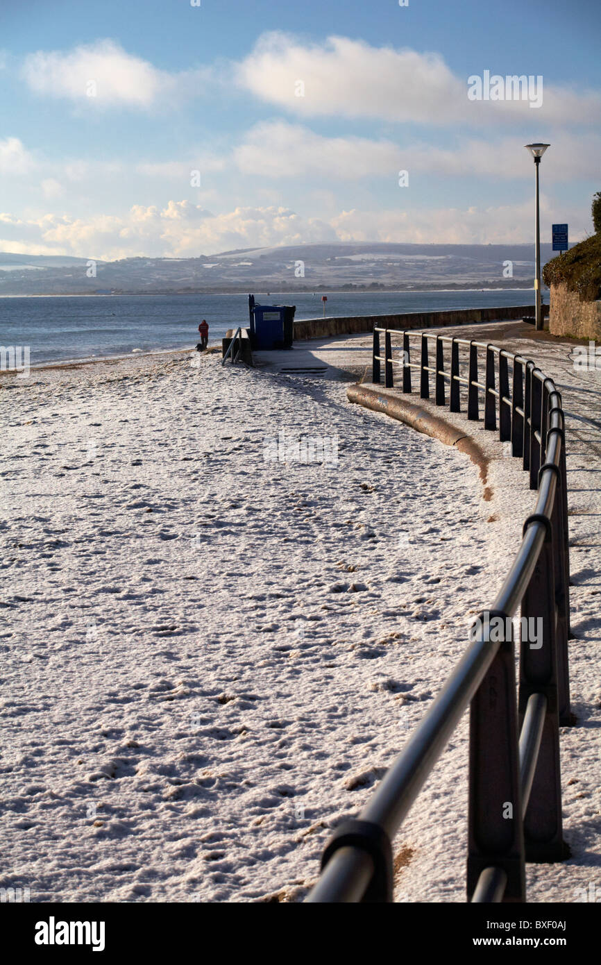 Coperta di neve in spiaggia a Poole, Dorset con neve oltre il Purbecks nella distanza Foto Stock