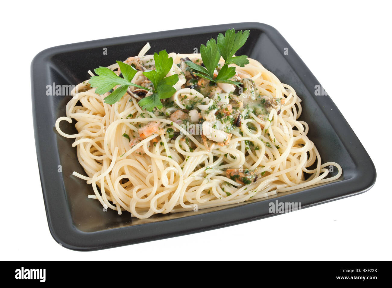 Spaghetti con gamberi, calamari, cozze e prezzemolo isolato su bianco con tracciato di ritaglio Foto Stock