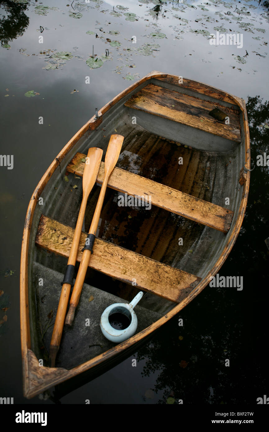 Un vecchio dalle intemperie riga in legno barca a remi e acqua brocca, vista da sopra. Foto Stock