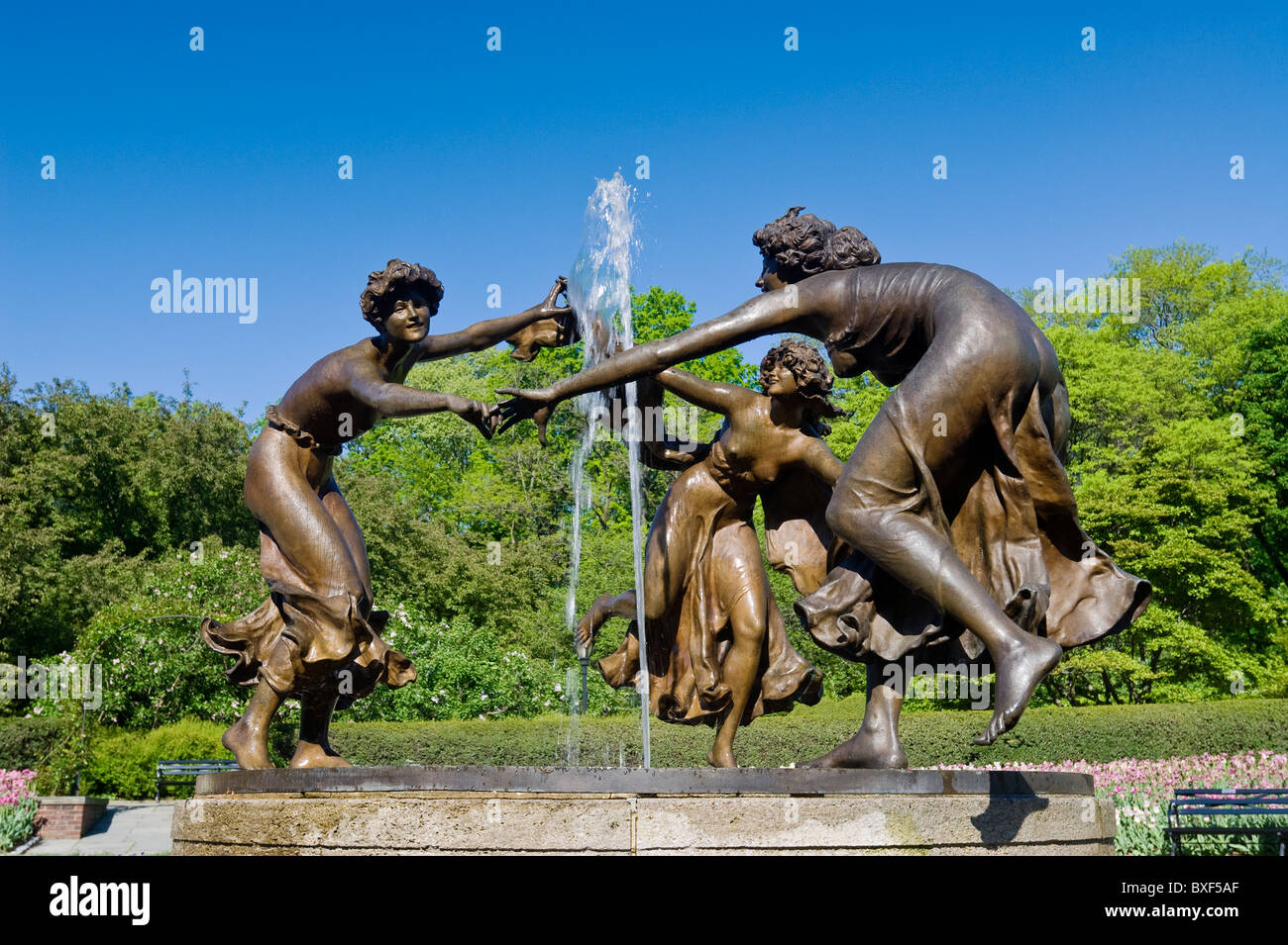 Giardino nel Central Park di New York City con la Danza tre pulzelle statua dello scultore Walter Schott. Foto Stock