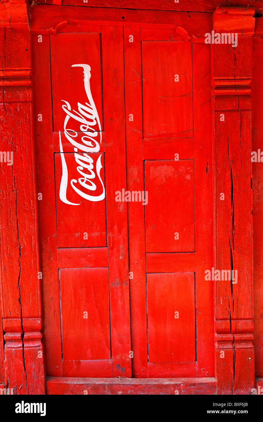 Nepal - Valle di Kathmandu - Bhaktapur - Coca Cola pubblicità dipinta su una porta Foto Stock