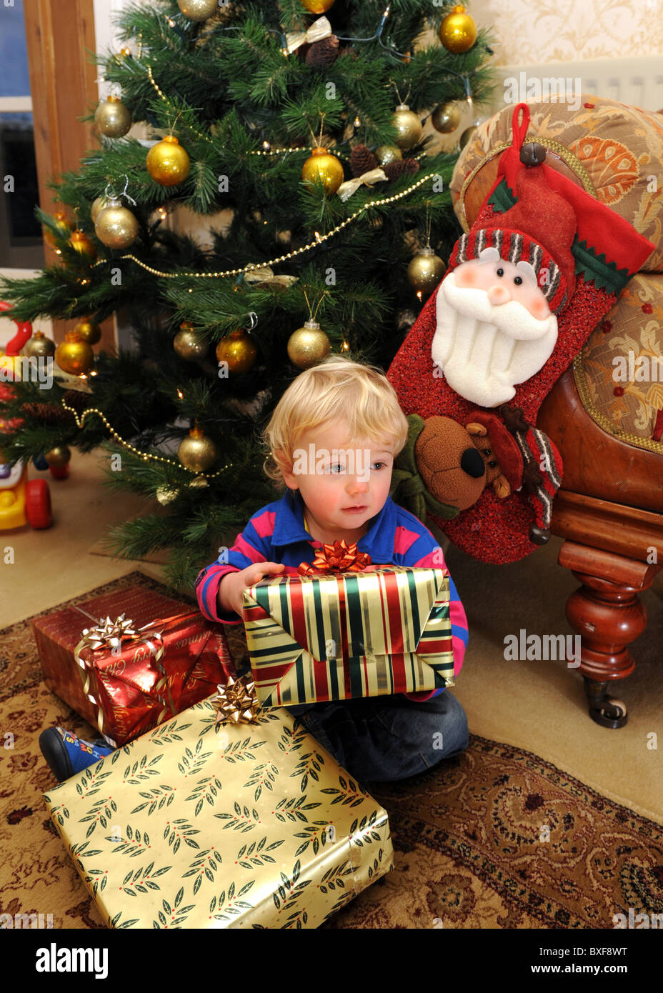 Apertura Regali Di Natale.Baby Boy Apertura Regali Di Natale Nella Parte Anteriore Dell Albero Di Natale Foto Stock Alamy