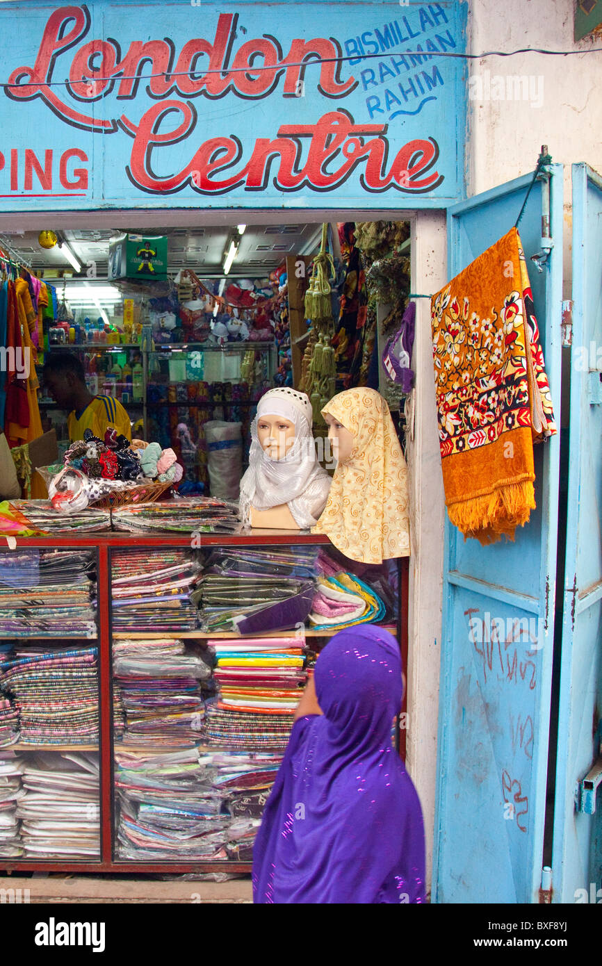 Ragazza guardando un velo musulmano shop a Mombasa, in Kenya Foto Stock