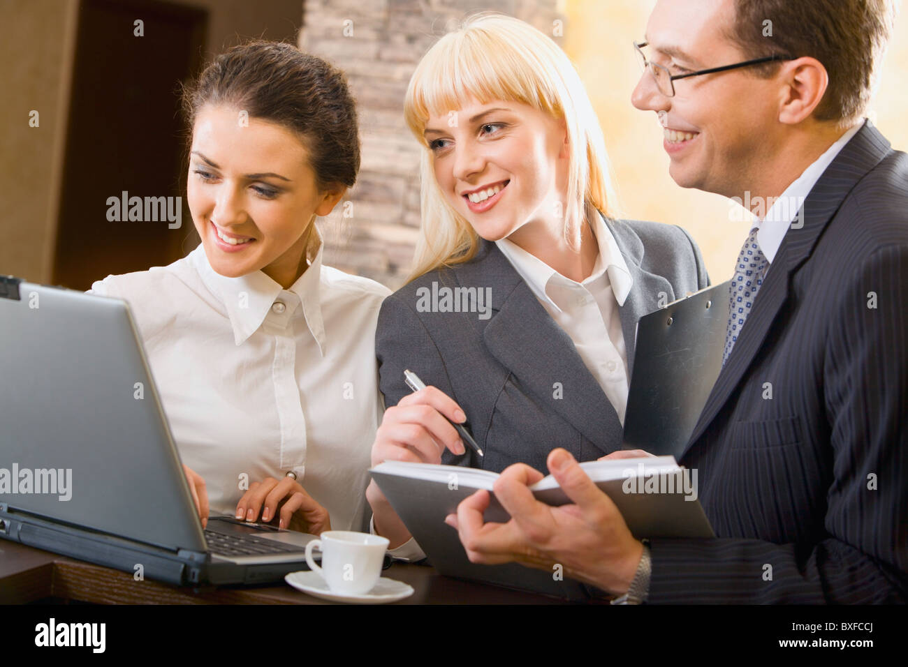 Ritratto di tre giovani specialisti fiducioso in occasione di una riunione Foto Stock