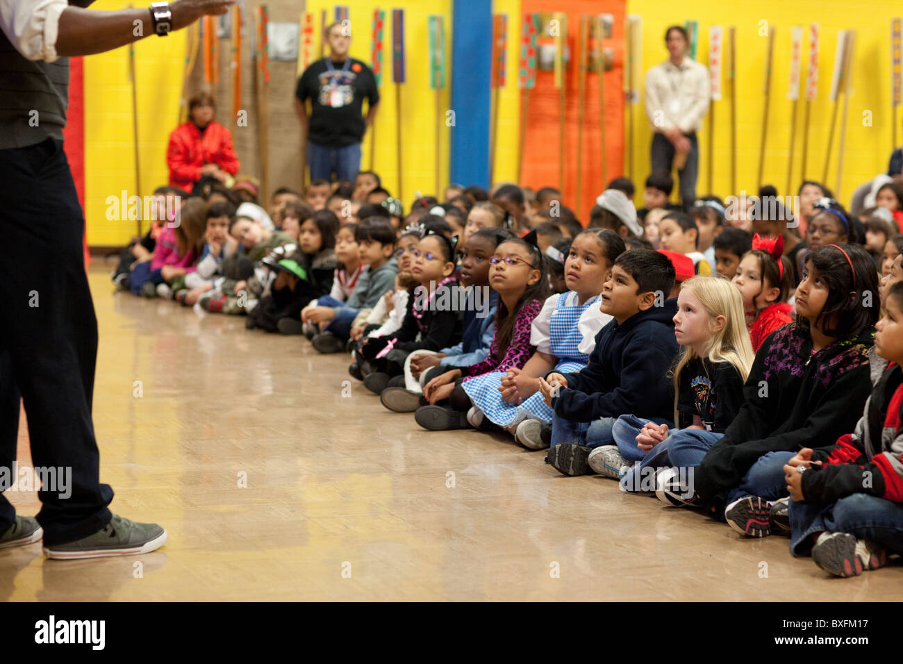 Elementare di terzo grado agli studenti di ascoltare i bambini di autore Derrick Barnes leggere da uno dei suoi libri a scuola insieme in Austin Foto Stock