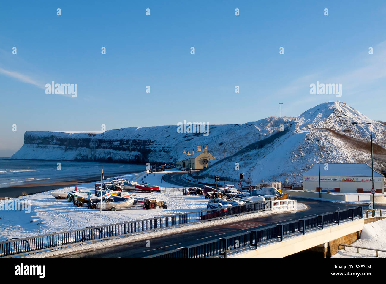 Saltburn dal mare spiaggia Huntcliff e barche da pesca coperto di neve pesante Foto Stock