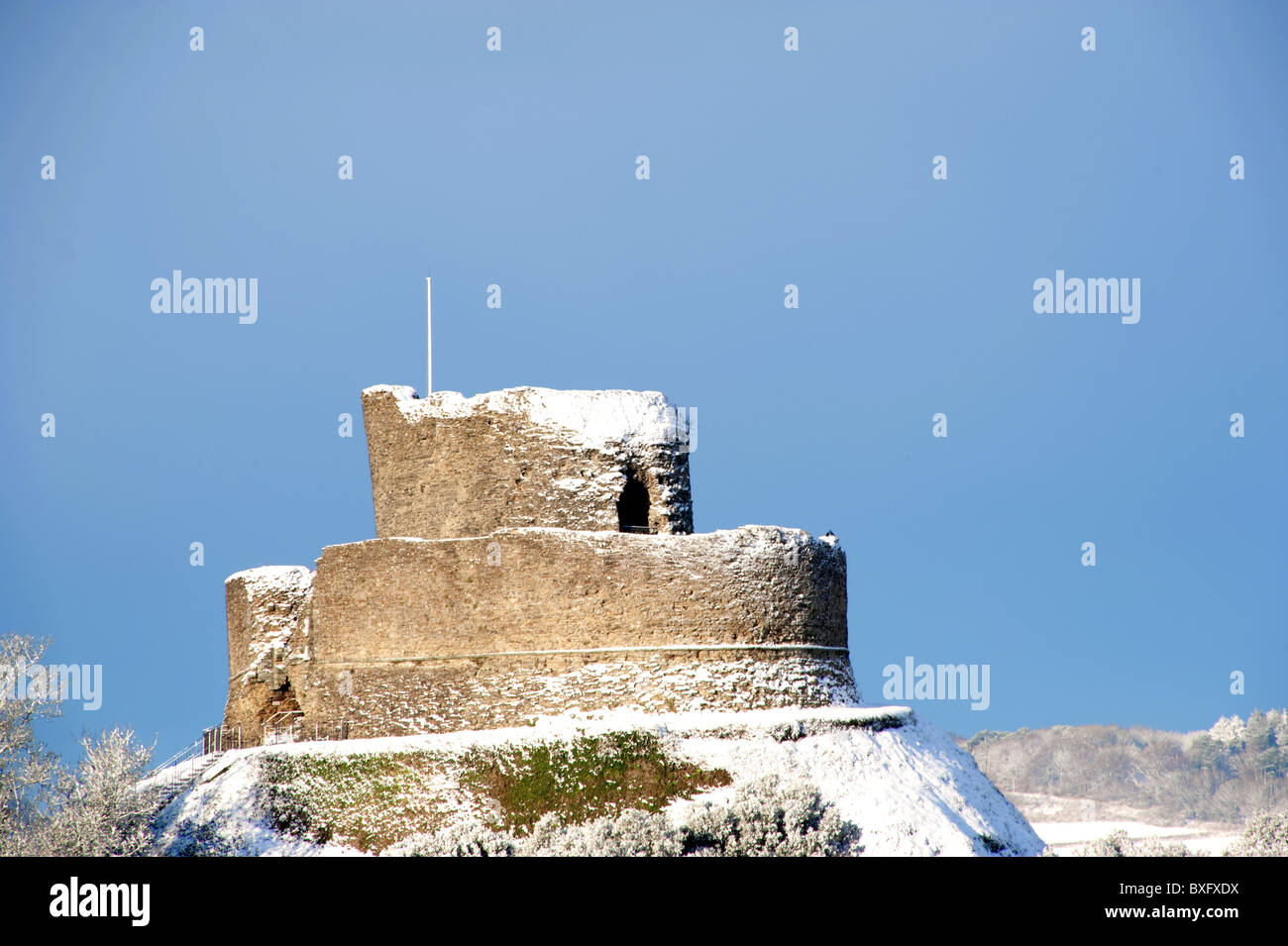 La doppia concentrici torri dei ruderi del Castello normanno a Launceston, parzialmente coperto con vento di neve soffiata. Foto Stock